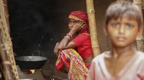 A tribal woman cooking food in a wood stove